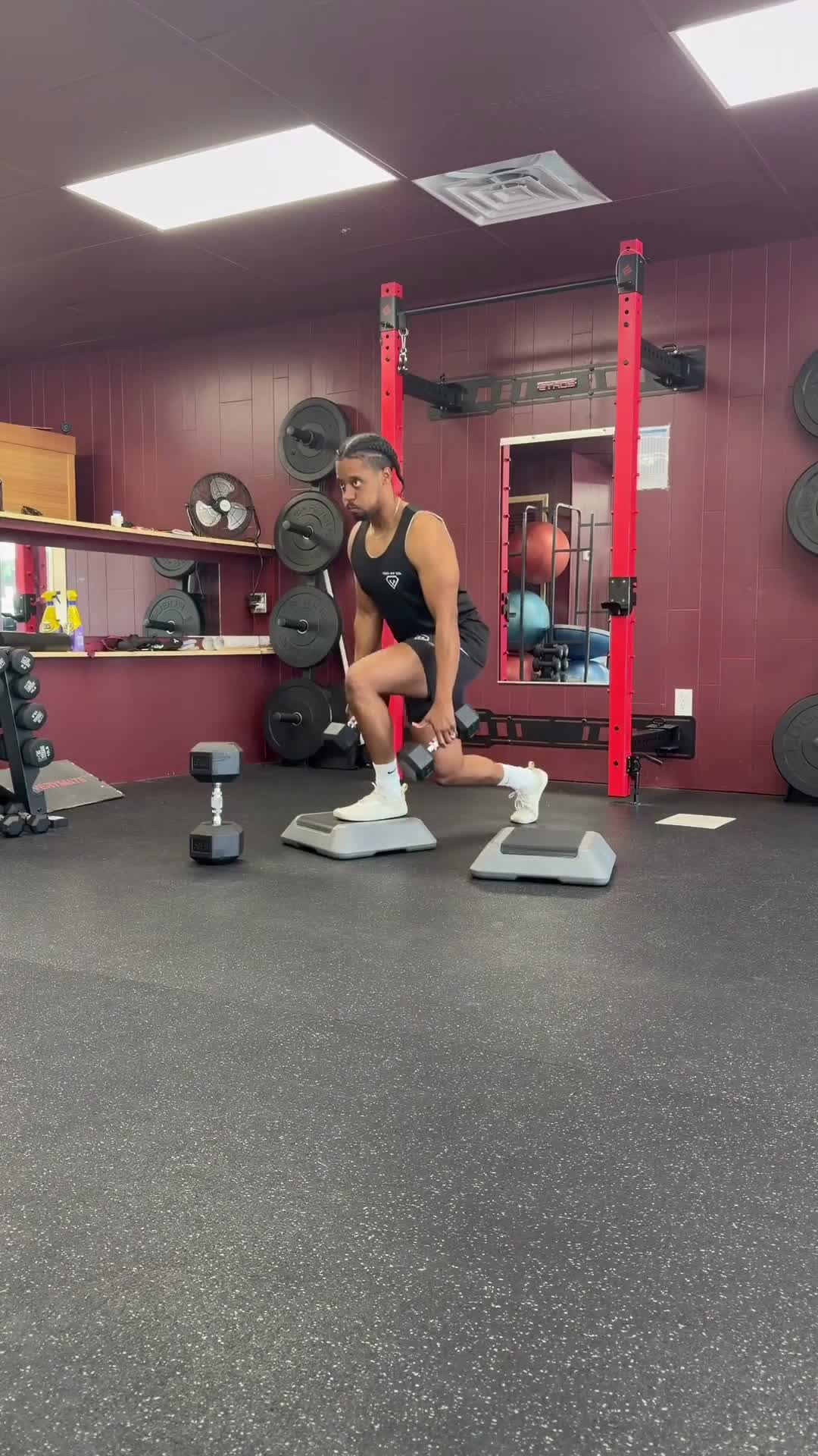 Athlete doing a dumbbell split squat in a gym