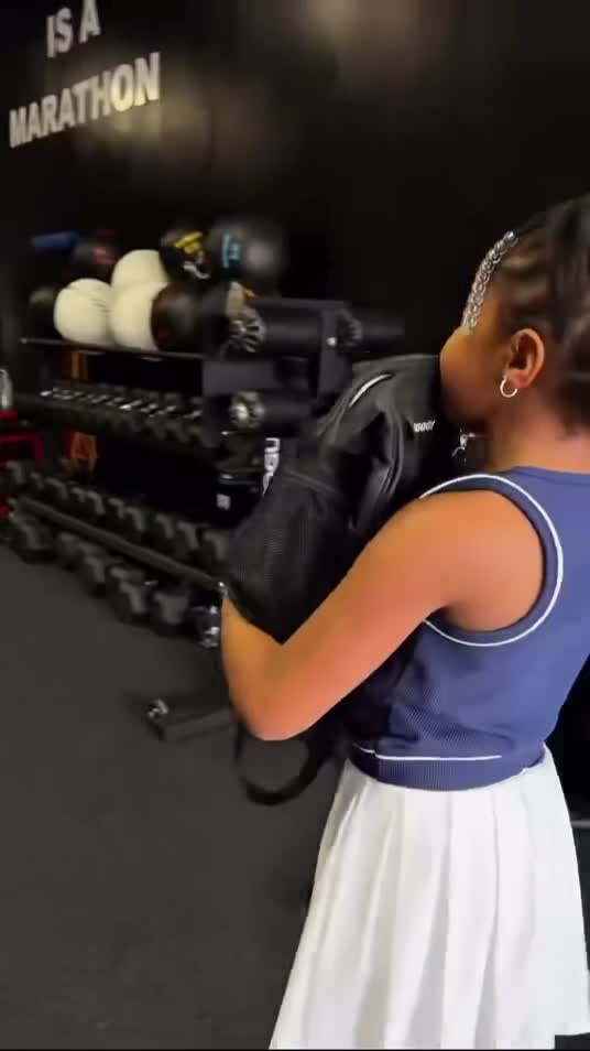 Member training with a sandbag in a gym